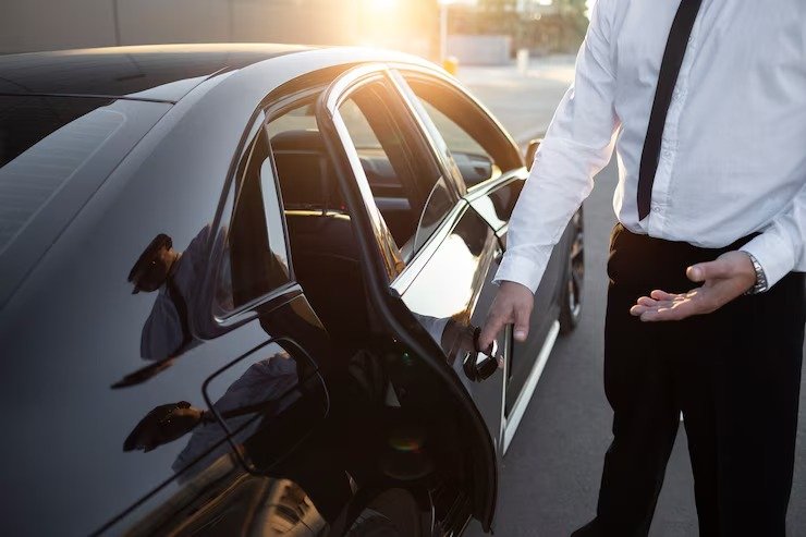 Professional chauffeur opening limo door for client in Ellicott City Maryland